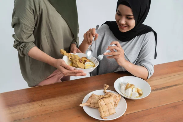 Vrouw geniet van ketupat en opor ayam — Stockfoto