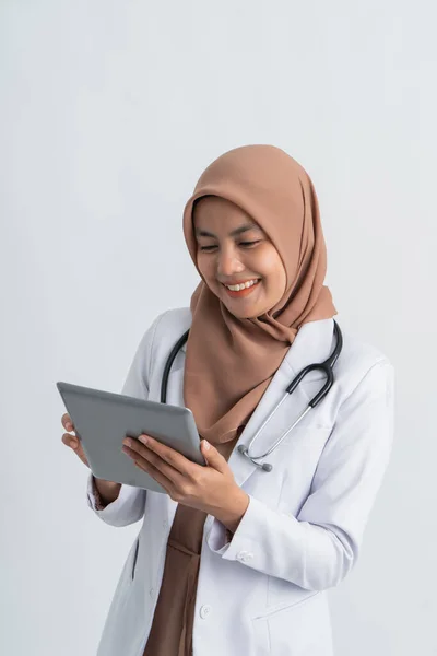 Muslimsk asiatisk kvinnlig läkare som använder tabletter pc — Stockfoto