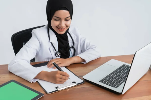 Мусульманская азиатка-врач работает — стоковое фото