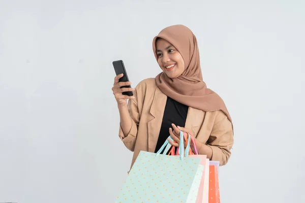 イスラム教徒の女性のショッピングホールド携帯電話 — ストック写真