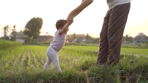 Anya segít neki, hogy a baba járni az első lépést — Stock videók