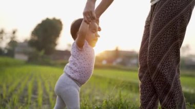 Anne bebeğinin ilk adımını atmasına yardım et.