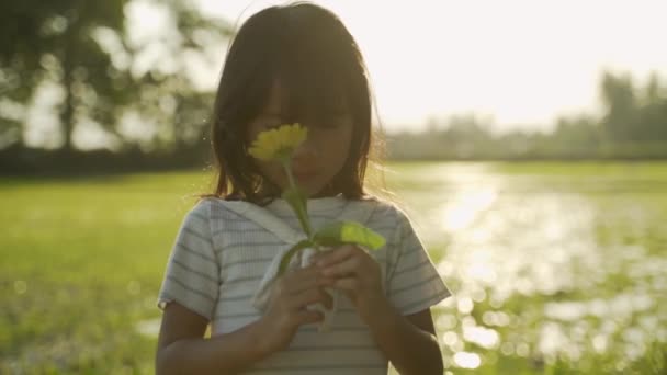 Asiatisches Kind riecht Blume — Stockvideo