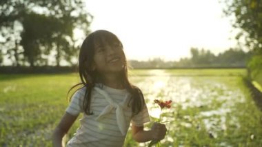 Sevgili Asyalı kızı annesine çiçek veriyor.