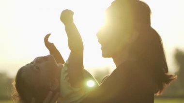 Anne ve bebek dışarıda birlikte oynuyorlar.