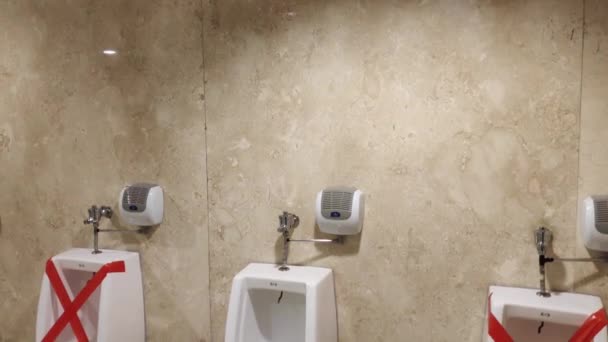 ЙОГЯКАРТА, ИНДОНЕЗИЯ - ИЮНЬ 2020 года: пустой общественный мужской туалет с табличкой социальной отдаленности — стоковое видео