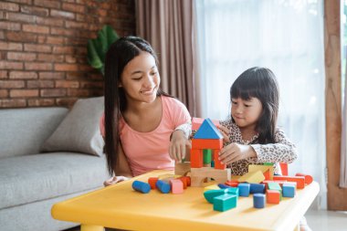 Mutlu kız kardeşler evde birlikte oynarlar.