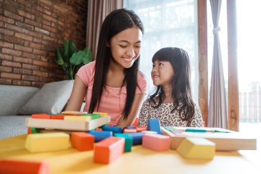 Mutlu kız kardeşler evde birlikte oynarlar.