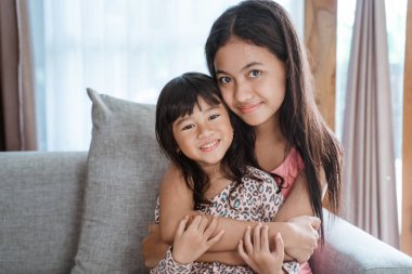 Kız kardeş kucaklaşıyor.