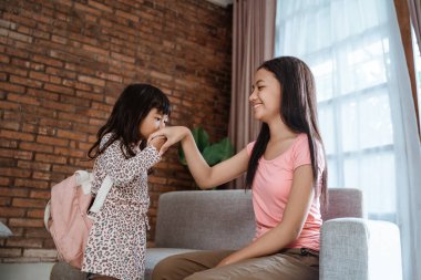 Çocuk el sıkışıyor ve ablamı öpüyor.