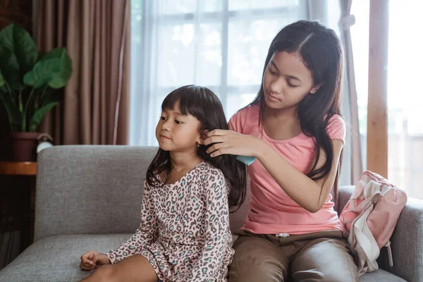 Geschwister helfen Schwester, ihre Haare zu bürsten — Stockfoto