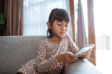 Sıkıcı çocuk cep telefonuyla oynuyor