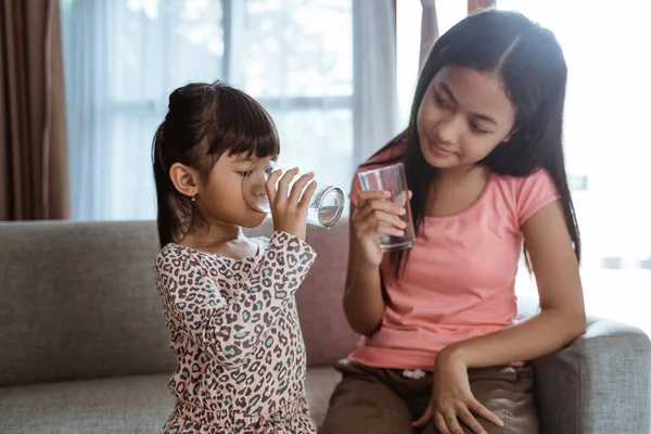 Sœur sœur ayant un verre d'eau à boire — Photo