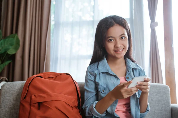 Adolescente usando smartphone enquanto sentado — Fotografia de Stock