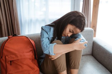 Üzgün genç kanepede oturuyor.