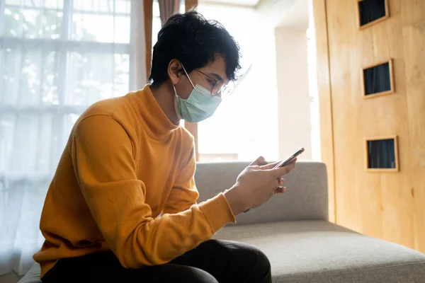 Homem doente usando máscaras médicas usando telefone celular — Fotografia de Stock