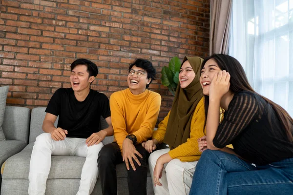 Gemeinsam auf der Couch sitzen und lachen — Stockfoto