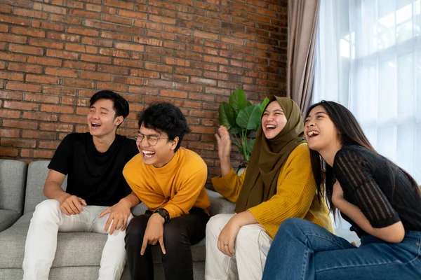 Duduk bersama di sofa tertawa bersama — Stok Foto