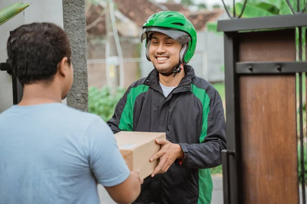 Man kurir med hjälm leverera paket till kund — Stockfoto