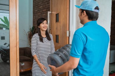 Kurye adam bir galon su getiriyor.