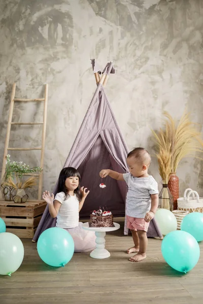 Los niños pequeños recogen cerezas y las hermanas mayores lo ven —  Fotos de Stock