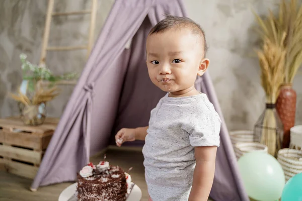 Menino com a boca coberta de creme olhou para a câmera — Fotografia de Stock