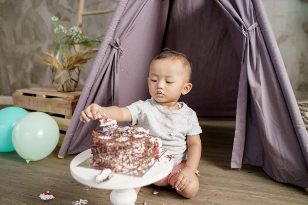 Menino segurando cerejas em um bolo de aniversário — Fotografia de Stock