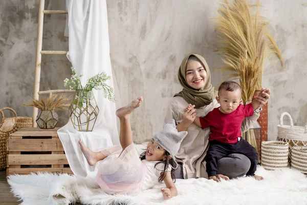 Madre y sus dos hijos sonríen al posar — Foto de Stock