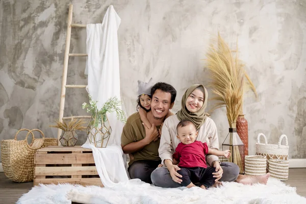 Keluarga Asia berpose tersenyum sambil duduk di atas karpet — Stok Foto
