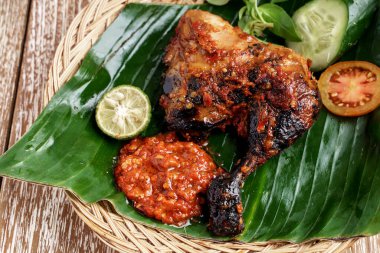 Izgara tavuğun yanında terazi ve taze sebze dilimleri.