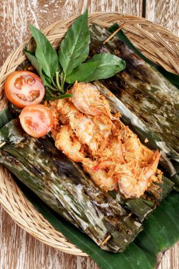 Baharatlı karides pepleri ve taze doğranmış domates ve fesleğen yaprakları.