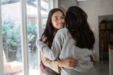 Anne okula gitmeden önce kızını kucaklıyor.