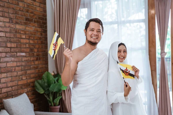 Esposa asiática y marido sosteniendo bandera nacional de brunei darussalam — Foto de Stock