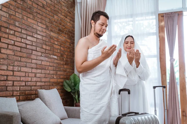 Мусульманский мужчина и женщина молятся с распростертыми руками — стоковое фото