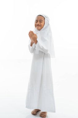 Müslüman çocuk dua ediyor ve ihram takıyor.