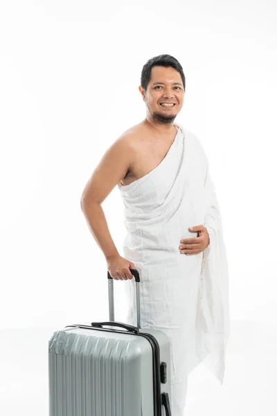 Χαρούμενος χαμογελαστός μουσουλμάνος άντρας με βαλίτσα που πάει για χατζ. — Φωτογραφία Αρχείου