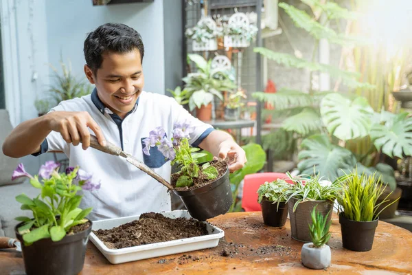 Ázsiai férfiak kezében cserepek és ültetési eszközök, hogy cserélje ki a talaj, mint a média — Stock Fotó