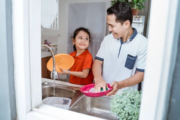 Putri membantu ayahnya mencuci piring — Stok Foto