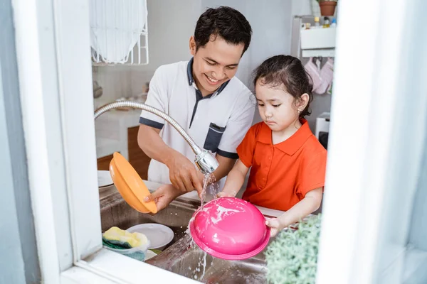 Hija ayudando a su padre a lavar platos — Foto de Stock