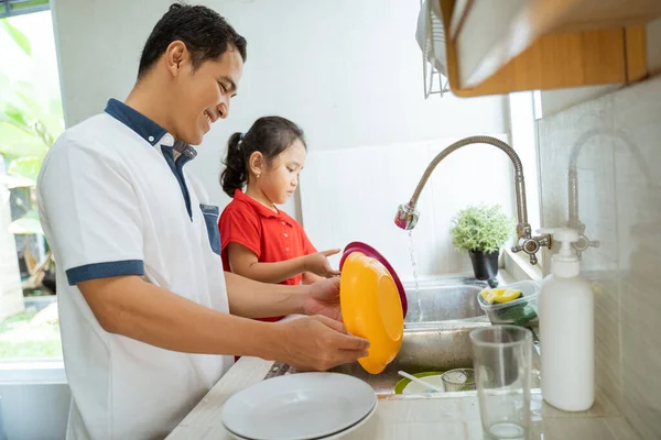 Hija ayudando a su padre a lavar platos — Foto de Stock