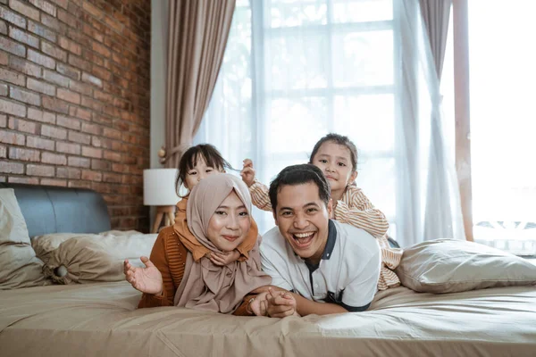 Keluarga asia yang ceria bersenang-senang bersama ketika berbaring di tempat tidur — Stok Foto