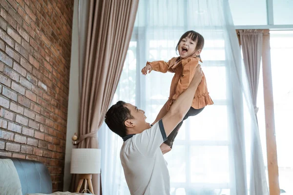 Menina riu feliz quando ela foi levantada por seu pai — Fotografia de Stock