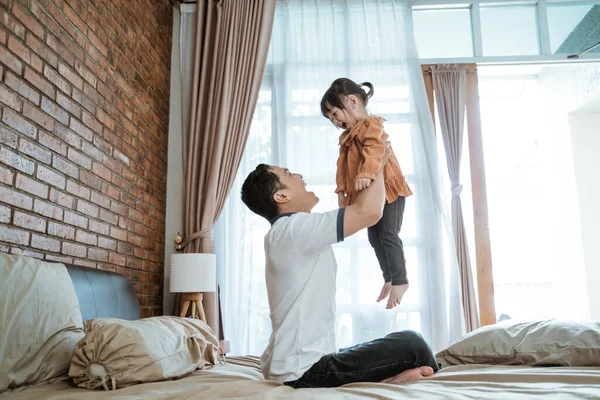 Menina riu feliz quando ela foi levantada por seu pai — Fotografia de Stock