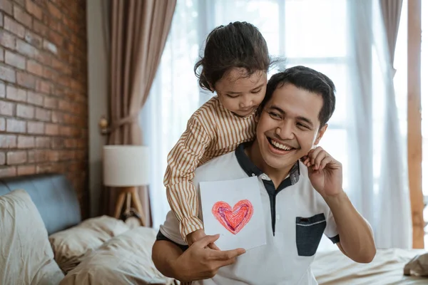 Asyalı küçük kız aşkının sembolü olarak babasına kalp çizilmiş bir kağıt veriyor. — Stok fotoğraf