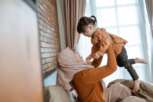 Aziatische gesluierde moeders verhogen tot up schattig kleine meisjes — Stockfoto