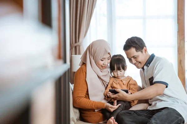 Asiatico musulmano famiglia insieme guardando un smartphone schermo — Foto Stock