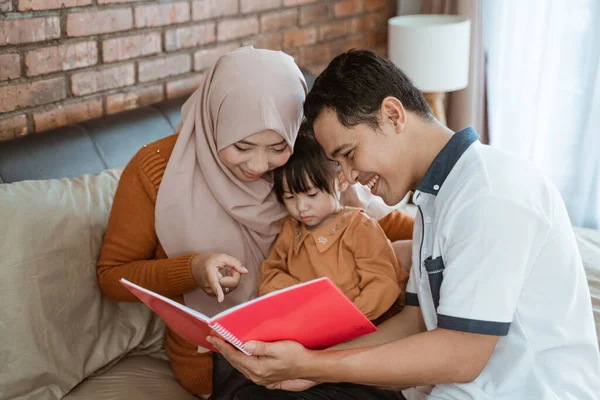 União de uma menina com seus pais ao ler um livro — Fotografia de Stock