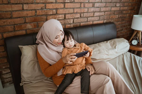 Klein meisje en moeder met behulp van een smartphone — Stockfoto