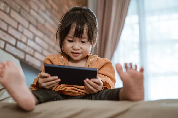 Little girl laughed happily when holding a phone — Stock Photo, Image