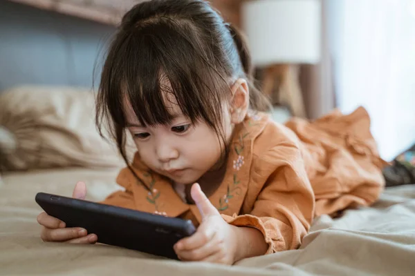 Little girl laughed happily when holding a phone — Stock Photo, Image